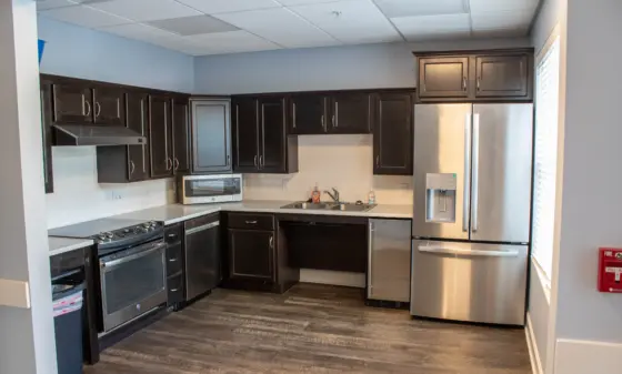 Modern kitchen with dark wood cabinets, stainless steel appliances, and a white subway tile backsplash.